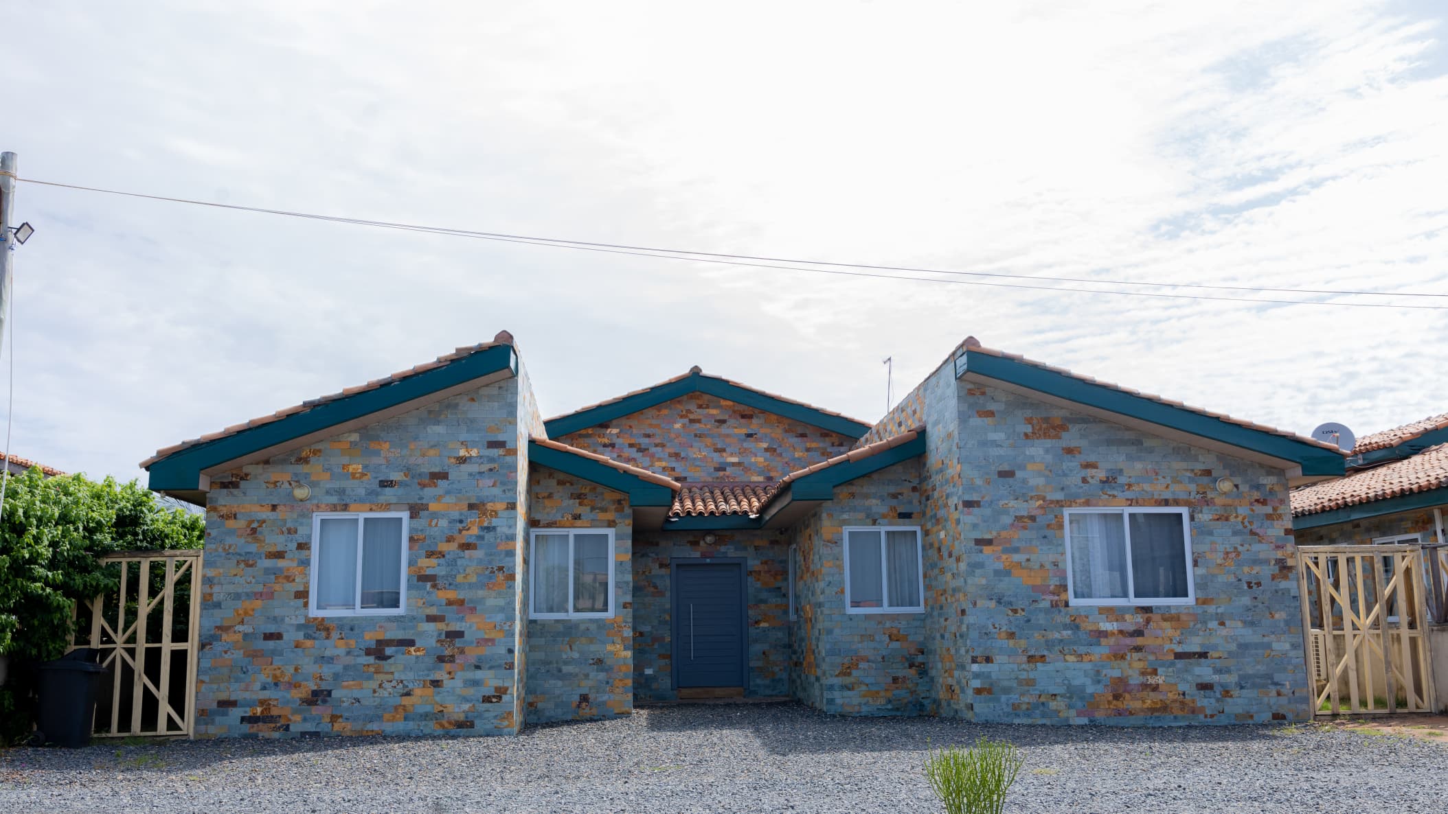 Modern cottage-style building with stone and blue roof accents